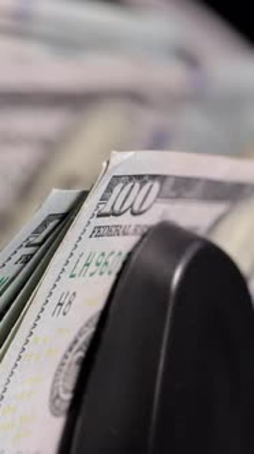 Money counting machine counting US bills. Vertical Video.