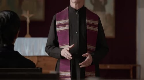 Senior Priest Speaking to Parishioners during Funeral Ceremony