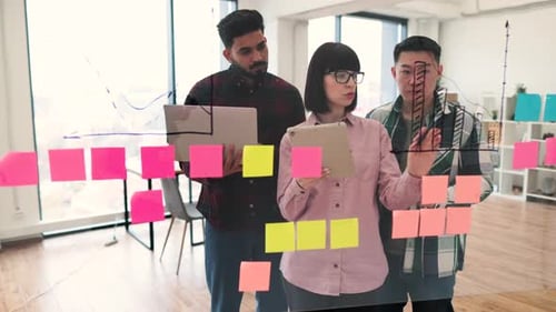 Creative Team Brainstorming with Charts and Sticky Notes