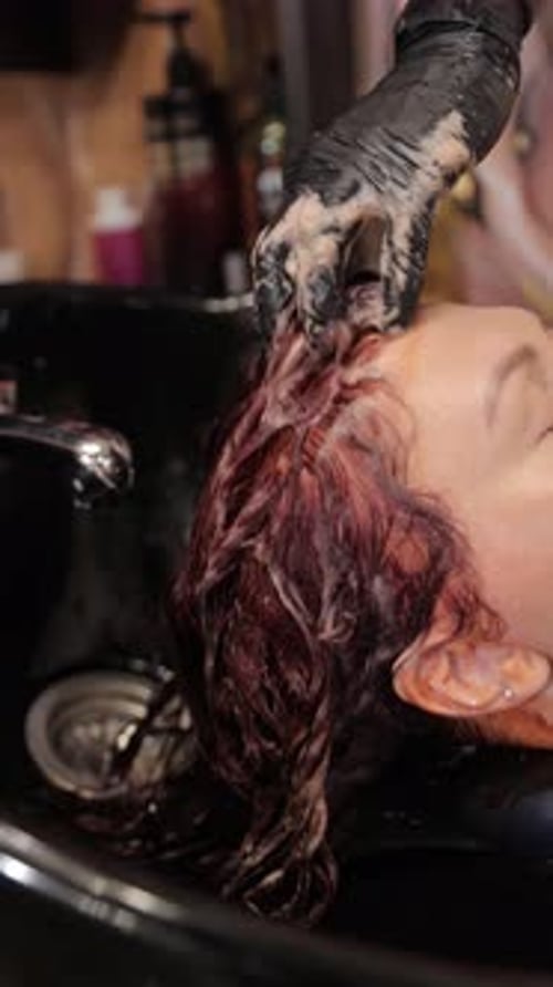 A Hair Coloring Process Showcasing a Woman As She Receives a Wash and Revitalizing Treatment at a