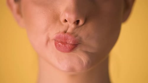 Très gros plan des lèvres d'une femme faisant des gestes sceptiques ou supérieurs avec sa lèvre