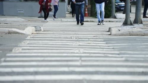Pedestrians crossing a street's crosswalk of a big city in daylight filmed in super slow motion in 4