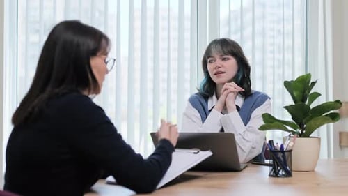 Teenage Girl College Student Talking with Counselor Psychologist in Office