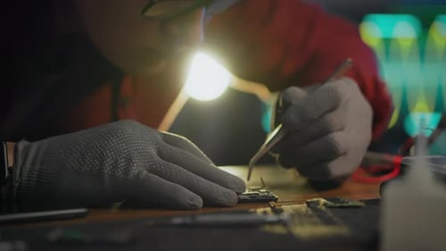 To correct. An engineer uses professional skills to repair a phone in an electronics laboratory. A