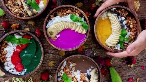 Top View of Beautiful Smoothies Bowls with Different Fruits and Berries on Table