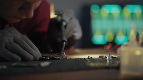 Industry. A repairman uses professional skills to repair a microcircuit in a prefabricated