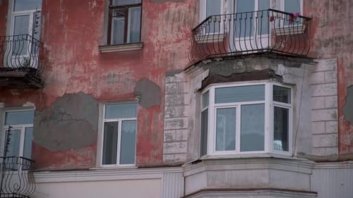 An old brick house wall with crumbled plaster