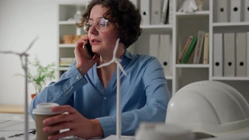 Electricity, Female Engineer Concentrated Sitting At Planning Desk Engineering Room Windmill