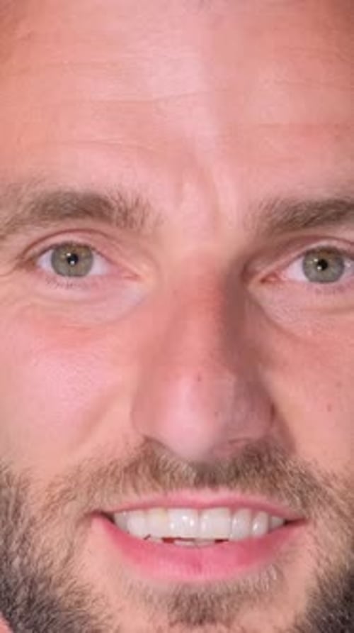 Closeup Portrait of a Handsome Brutal Man with a Beard Looking at the Camera and Smiling Vertical