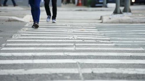 Pedestrians crossing a street by the crosswalk of a big city in daylight filmed in super slow motion