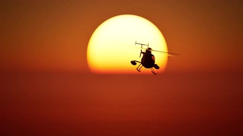 Helicopter against sunset background