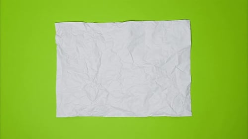 Video Top View of Wrinkled Textured White or Light Gray Paper on Bright Green Table White Crumpled