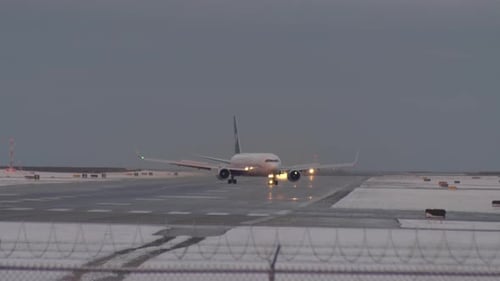 Passenger Airplane Taxiing On The Airport Taxiway On A Winter Evening. wide