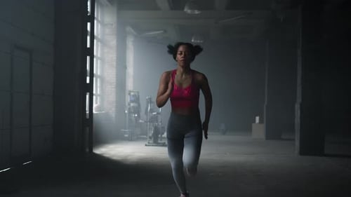 Energetic Woman Running Fast in Modern Gym. Female Athlete Jogging in Sport