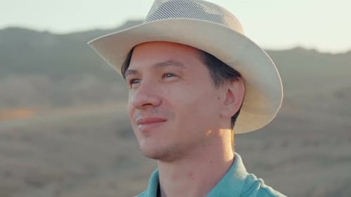 Happy Adult Young Caucasian Man with Unshaven Face and Brown Eyes Wearing a White Hat Against the