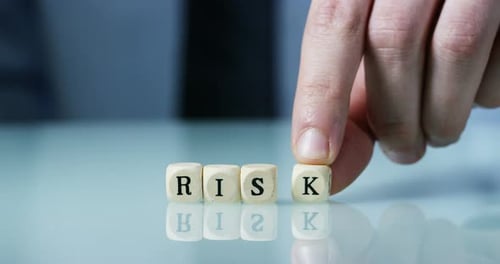 Slow motion macro of the word "Risk" made of the wooden letter blocks . Concept of financial marke