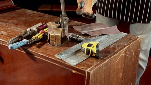 Furniture Repairman in a Special Protective Apron in a Working Workshop Works with Tools and