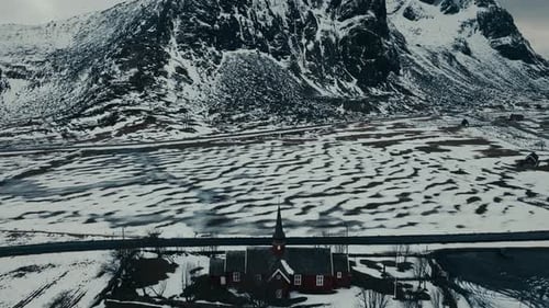 Vue ci-dessus de l'église de Flakstad dans un paysage enneigé à Ramberg dans les îles Lofoten, en Norvège. Prise de vue aérienne par Drone