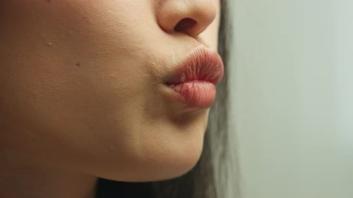 Gros plan de belles lèvres charnues féminines séduisantes embrassant une fille s'embrasse en studio, asiatique méconnaissable, inconnue