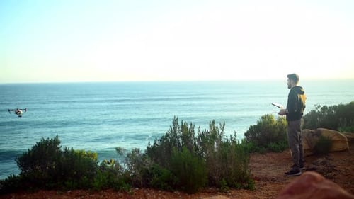 Drone, photography and man with technology on beach filming nature, water or landscape