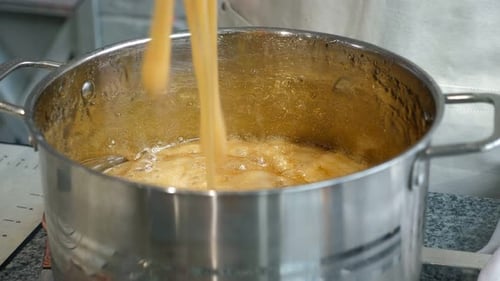 Closeup Liquid Caramel Boils in a Small Saucepan in a Professional Pastry Shop