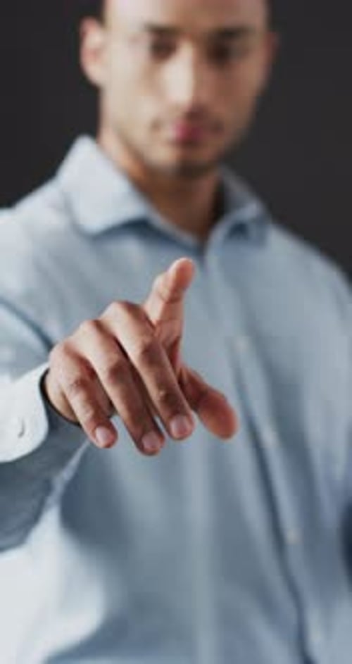 Vidéo verticale d'un homme d'affaires biracial pointant du doigt, utilisant un écran holographique, un espace de copie