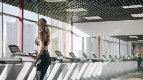 Young Woman Training on Treadmill in Fitness Club. Pretty Fitness Woman Training