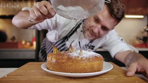 Closeup Man Chef at Restaurant Kitchen Serves Dish Adding Ingredient By Hand