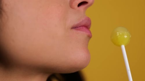 Jeune femme sexy mangeant Chupa Chups en gros plan, lèvres de femme, sucer une sucette, concept sensuel, espace de copie