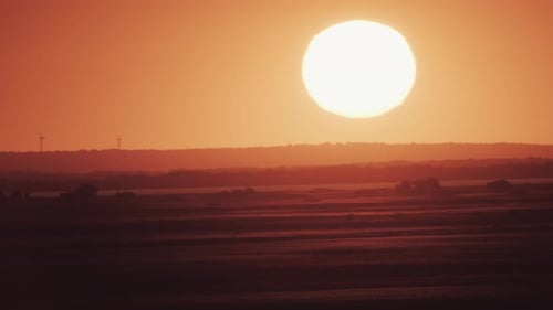 Big Sun at Sunset with Wind Turbines