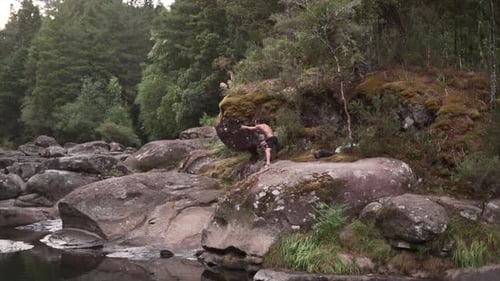 Man Photographer Filming with a Gimbal on the Rocks of the Mclaren Waterfall New Zealand