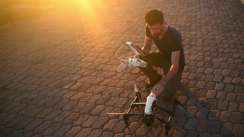 Sunrise, morning and man with drone and tablet for photography, aerial view and cityscape