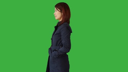 Pantalla verde de una mujer de pie con un panel táctil en la mano