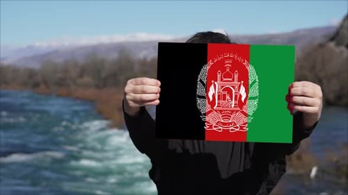 Person Holding Banner With Flag Of Afghanistan