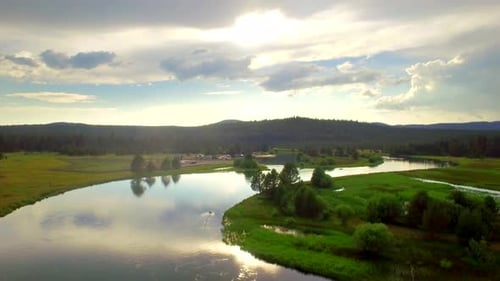 Oregon river bends flowing through a forest landscape at sunset by drone