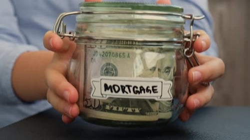 Female Hands Put on Table Glass Jar Full of American Currency Dollars Cash Banknote with Text