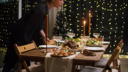Festive Dinner at Home Woman Blowing Out Candles on Dining Table