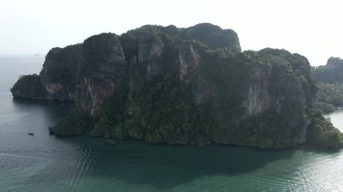 Steep Cliffs of Railay Peninsular Coast with Many Travel Ships Drifting in a Sea Krabi Thailand