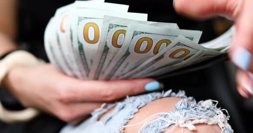 Closeup of an anonymous woman hold in hands and counting new one hundred dollar bill banknotes