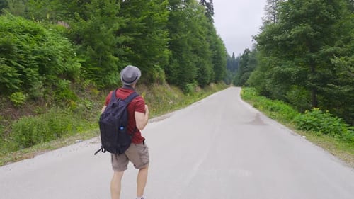 Lonely man walking on the road in the forest.