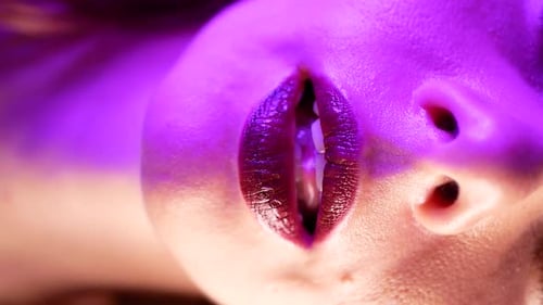 Une femme sexy lèche séduisamment ses lèvres à la caméra