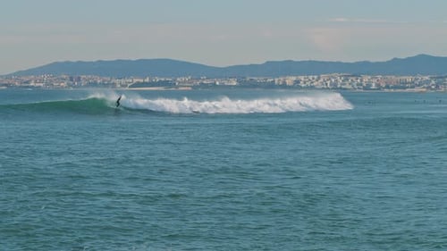 Surfer catching wave in the Atlantic ocean near the Lisbon coast, Portugal.