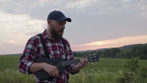 Close Up Charming Farmer Plays on His Guitar