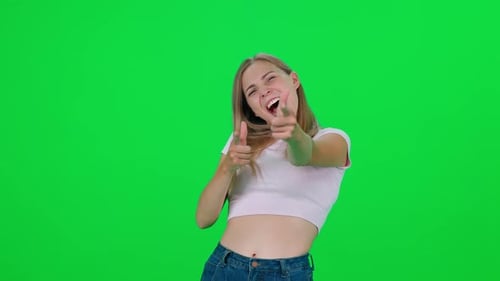 Mujer caucásica de pie en una habitación verde y mira a la cámara: Chroma Key Background: la joven