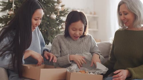 Fille asiatique heureuse recevant un ours pour Noël de la part de sa famille