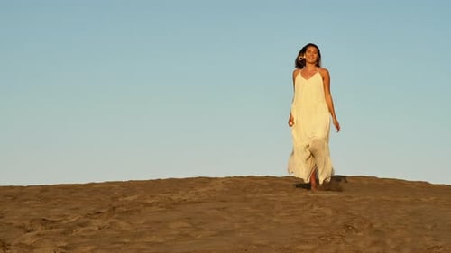 Stunning Woman in Flowy Dress Running Down the Sand Dune