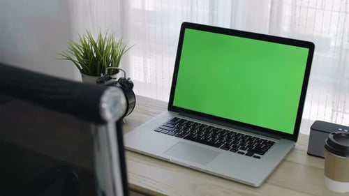 Green screen of laptop computer set on working space in cozy office, Zoom out shot