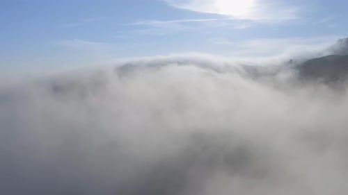 Cinematic Nature. Drone View Flying Through Thick White Fog Clouds at Sunrise