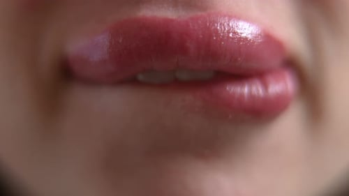 Bouche en gros plan d'une femme méconnaissable mordant la lèvre inférieure au Ralenti