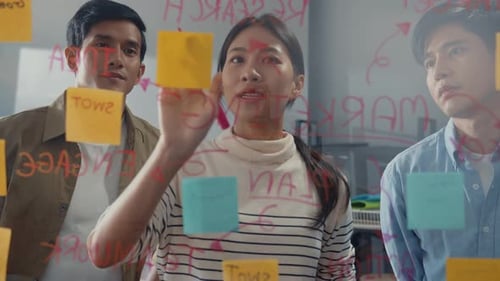 Asia businesspeople stand behind transparent glass wall listen manager pointing progress work.